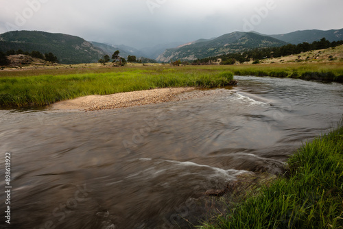 The Big Thompson River courses its way through Moraine Park as the morning rains fall on the distant mountains within Rocky Mountain National Park, Colorado in mid-July