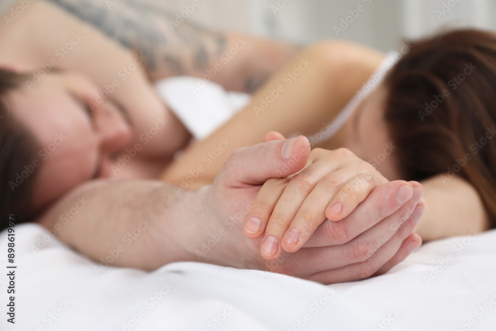 Lovely couple holding hands in bed, closeup Lovely couple holding hands in bed, closeup