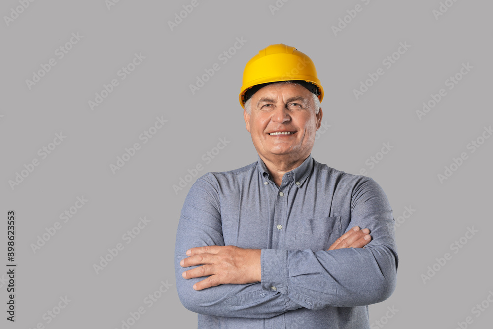 Engineer in hard hat on grey background, space for text Engineer in hard hat on grey background, space for text