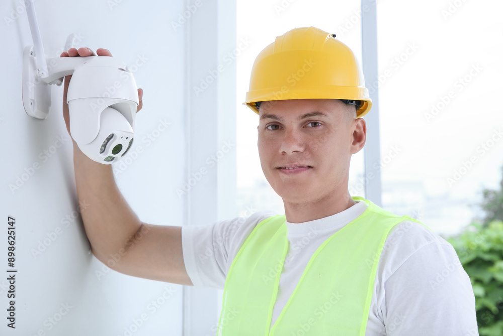 Portrait of technician in helmet near CCTV camera Portrait of technician in helmet near CCTV camera