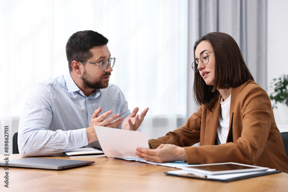 Consultant working with client at table in office Consultant working with client at table in office