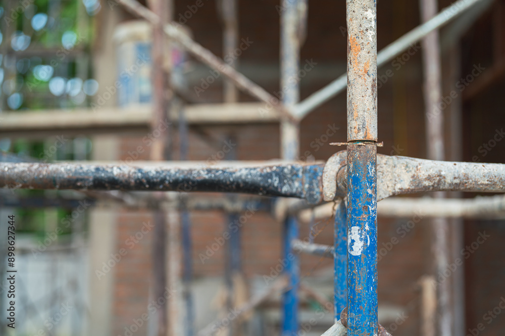 Close-up at metal scaffolding structure at the housing construction building site. Industrial working equipment object photo, selective focus. Close-up at metal scaffolding structure at the housing construction building site. Industrial working equipment object photo, selective focus.