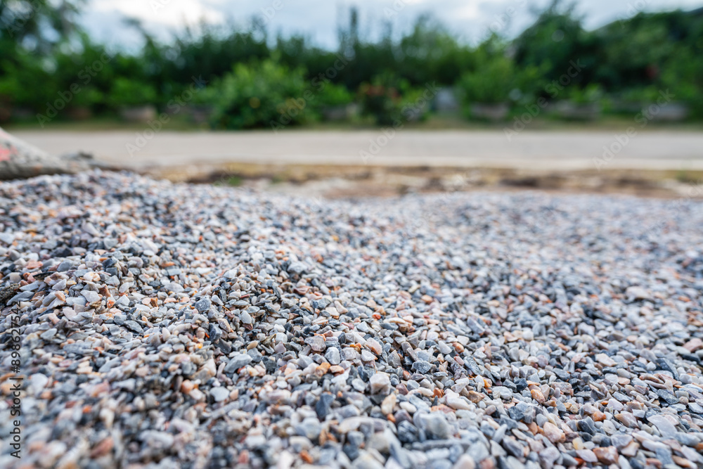 Bulk of crushed rock or pebble rock, material for house building, that placed on the construction work site. Close-up and selective focus.