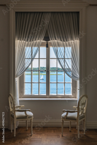 interior with two chairs near a window with a view to a lake 
