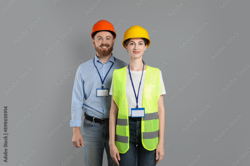 Engineers in hard hats on grey background Engineers in hard hats on grey background