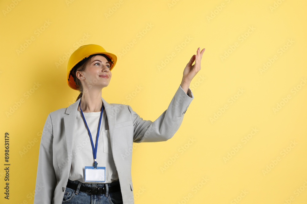 Engineer in hard hat on yellow background, space for text Engineer in hard hat on yellow background, space for text