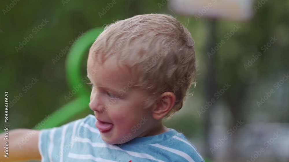Little boy in the rain. Wet happy little child playing on playground in rain in summer. Little boy in the rain. Wet happy little child playing on playground in rain in summer.