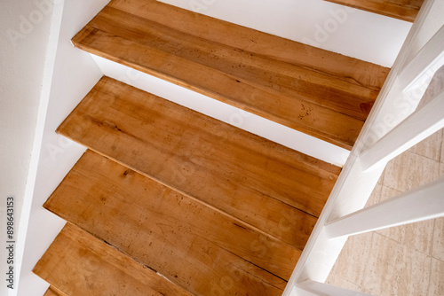 The image displays a close-up view of wooden stairs with white bordering edges, giving a rustic and clean appearance perfect for interior design inspiration.