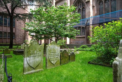 Old gravestones with lush green grass at Trinity Church in New York City photo