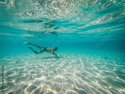 man swimming and snorkeling in clear blue sea