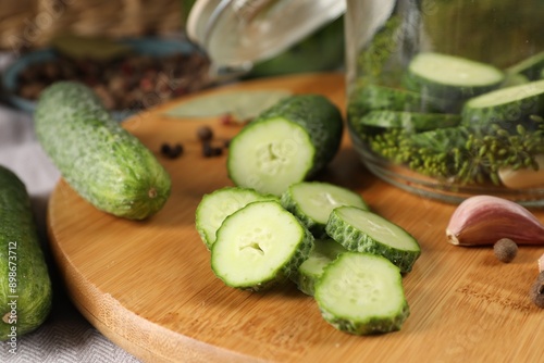 Board with fresh cucumbers and spices on table, closeup