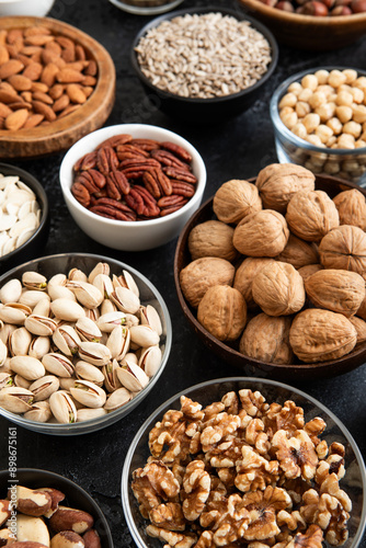 Raw walnuts and cashew with almonds and peanuts with organic nuts and seed in various assorted bowls.Macro