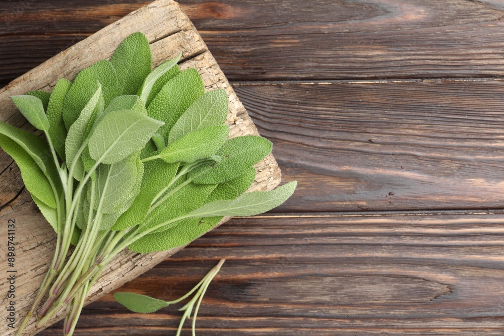 Obraz premium Green sage leaves on wooden table, top view. Space for text
