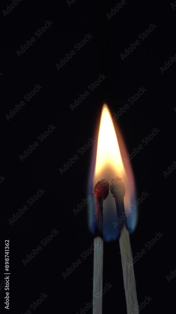 two burning matches that connect into one flame close up. Black abstract background with flame, copy space two burning matches that connect into one flame close up. Black abstract background with flame, copy space