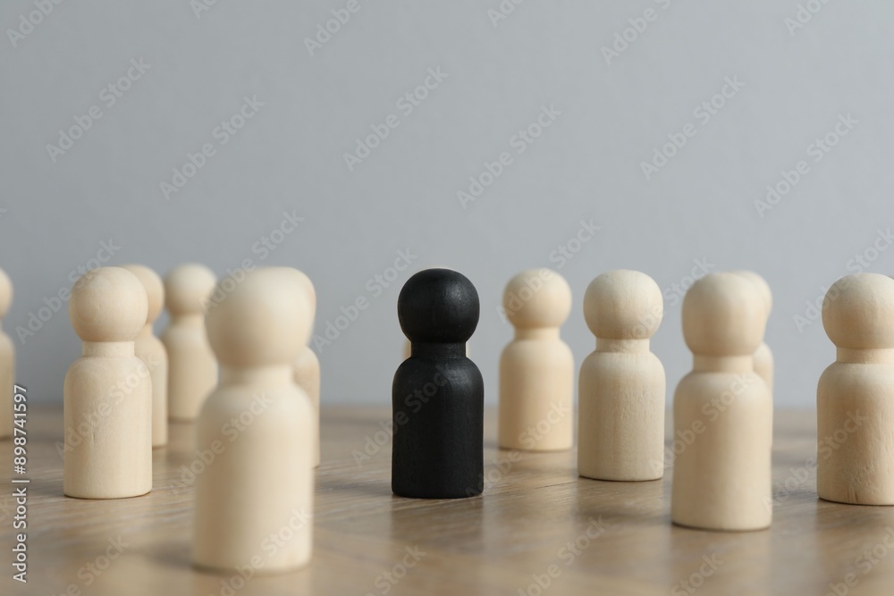 Black piece among wooden ones on table Black piece among wooden ones on table