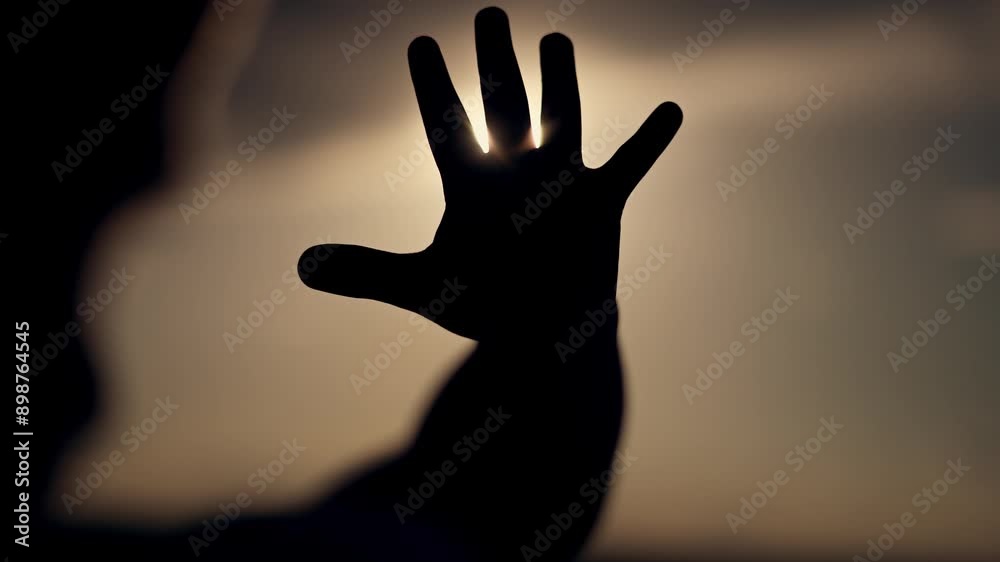 Child hand reaching towards sun. Dream touching sun. Silhouette hand against sunset. Cinematic concept of child reaching for dreams. Inspirational moment for child. Dream of child's hand touching sun. Child hand reaching towards sun. Dream touching sun. Silhouette hand against sunset. Cinematic concept of child reaching for dreams. Inspirational moment for child. Dream of child's hand touching sun.