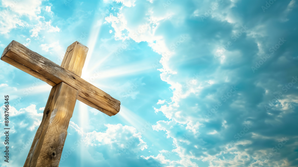 wooden cross is placed against the blue sky with white clouds with sunlight shining wooden cross is placed against the blue sky with white clouds with sunlight shining