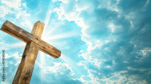 wooden cross is placed against the blue sky with white clouds with sunlight shining