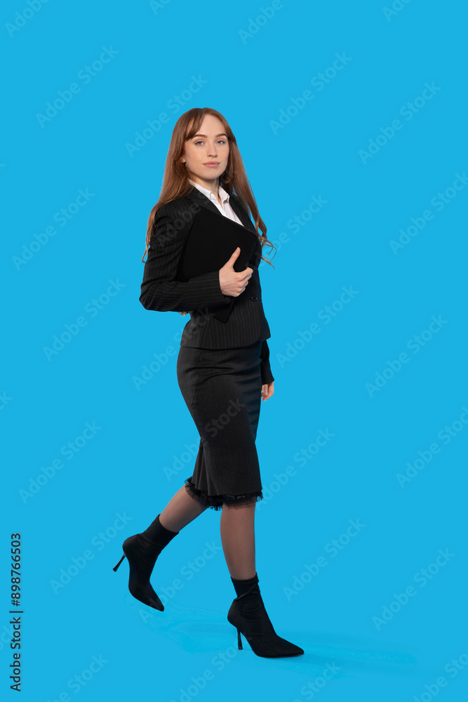 Woman In Black Suit Walking On Blue Background Woman In Black Suit Walking On Blue Background