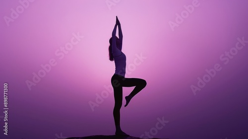 Obraz na płótnie Silhouette of a woman practicing yoga at sunset, holding the tree pose with a purple sky in the background w salonie