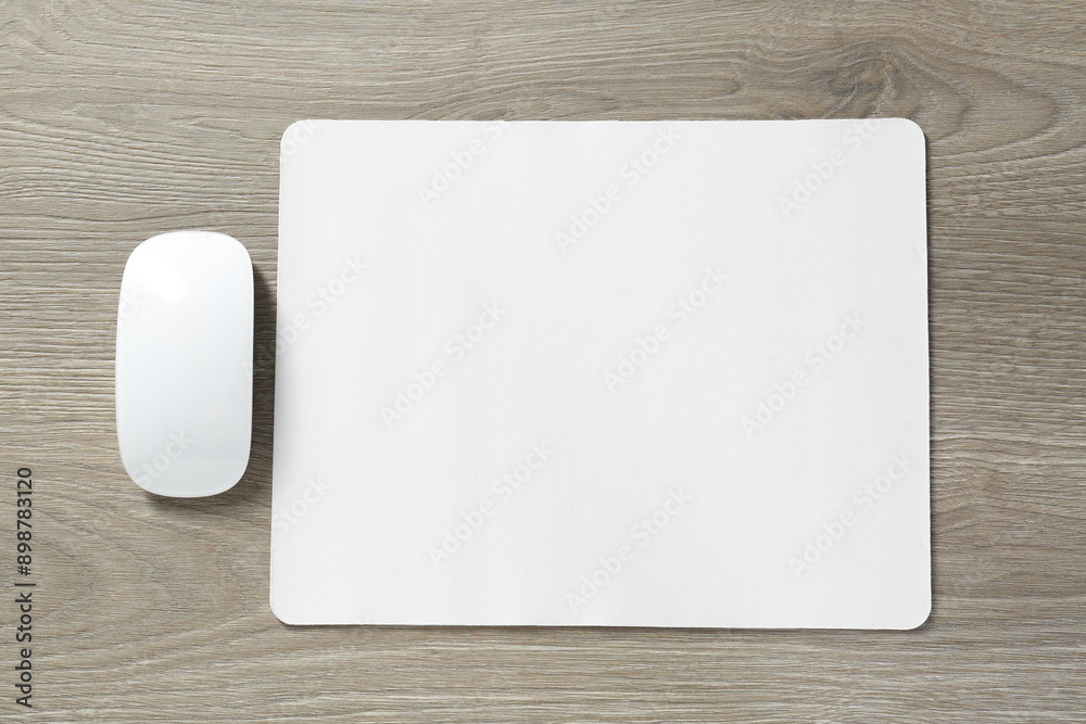 Wireless mouse and mousepad on wooden table, top view Wireless mouse and mousepad on wooden table, top view