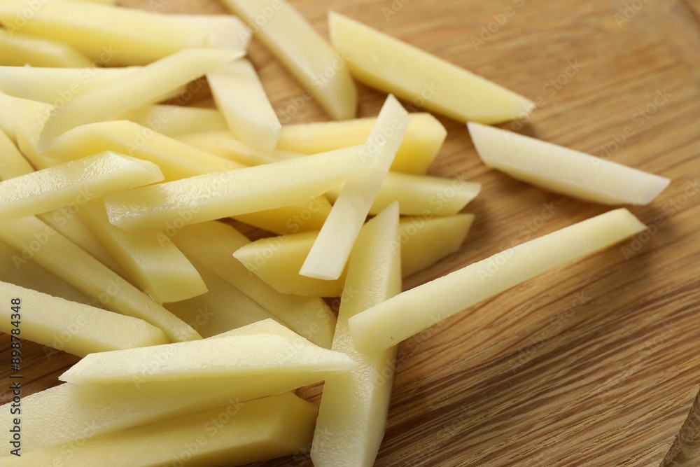 Cut fresh raw potatoes on wooden table, closeup Cut fresh raw potatoes on wooden table, closeup
