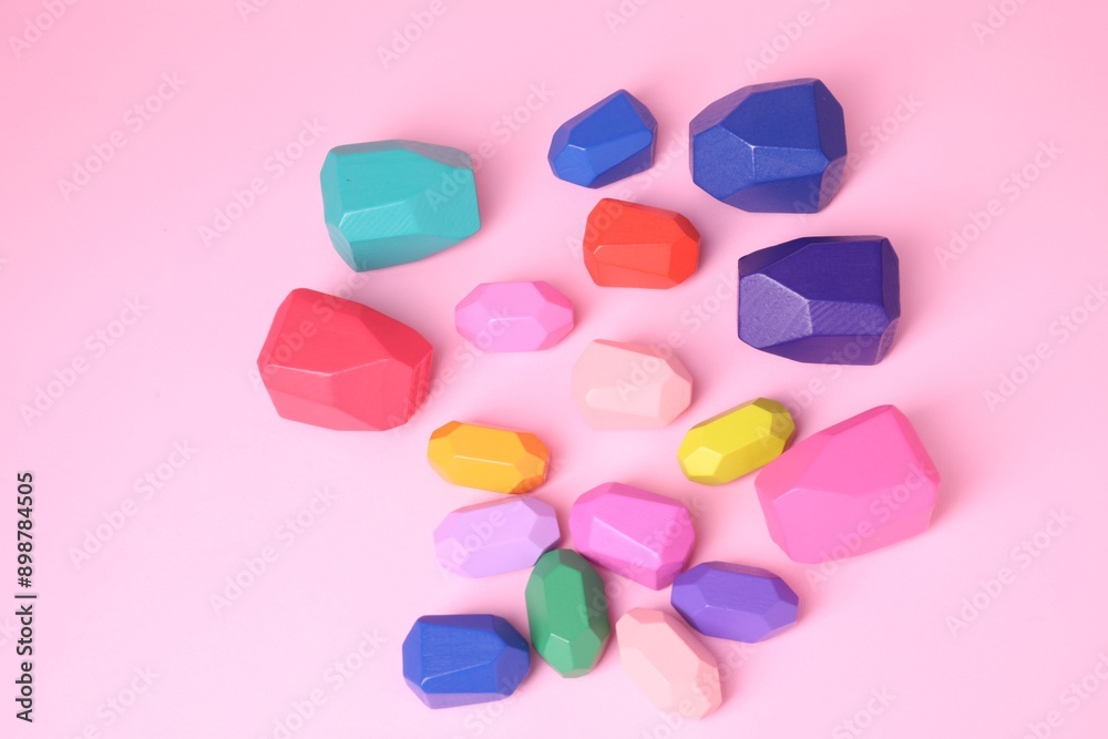 Many colorful balancing stones on pink background, top view Many colorful balancing stones on pink background, top view