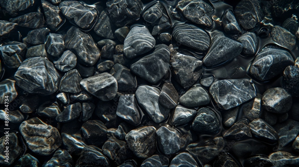 Anthracite pebbles underwater with reflections of light, aesthetic minimalist background