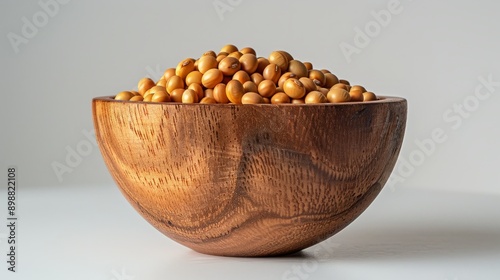 Soybeans piled in wooden bowl with neutral background