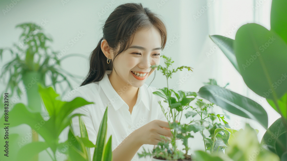 Feature our office plant care system with automatic watering, with a smiling Asian girl tending to plants on a plain white background. Feature our office plant care system with automatic watering, with a smiling Asian girl tending to plants on a plain white background.