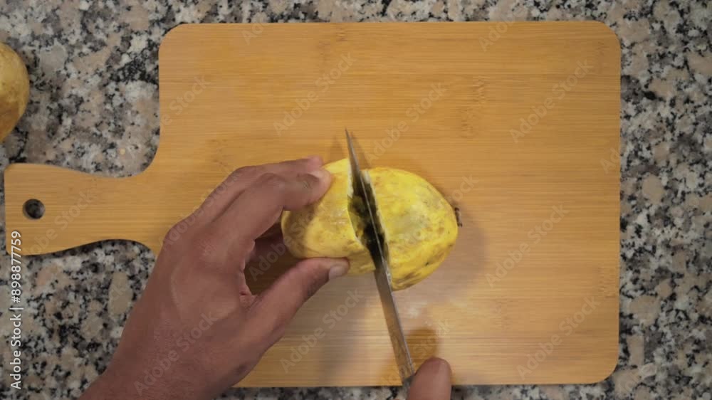 Manos con cuchillo cortando fruta de maracuyá por la mitad para hacer jugo delicioso en cámara lenta