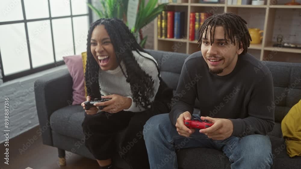 A joyful young couple plays video games in a cozy living room, exuding energy, fun, and togetherness. A joyful young couple plays video games in a cozy living room, exuding energy, fun, and togetherness.