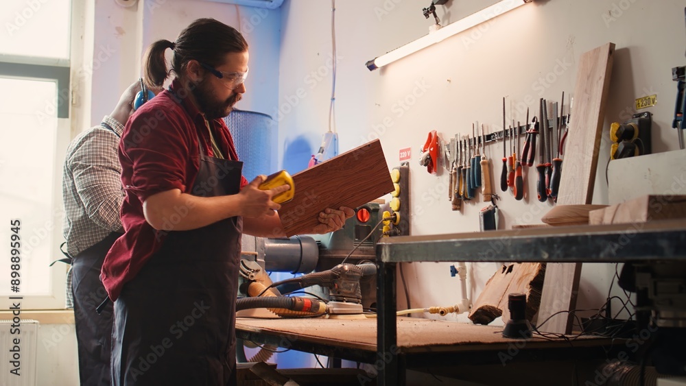 Artisan next to coworker using sanding block to remove imperfections on wood piece. Creative person enjoying diy hobby, using sandpaper to do manual sanding near african american colleague, camera B Artisan next to coworker using sanding block to remove imperfections on wood piece. Creative person enjoying diy hobby, using sandpaper to do manual sanding near african american colleague, camera B