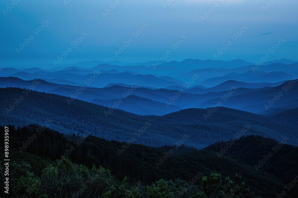 A view of a mountain range at sunset with the sky ablaze in warm colors A view of a mountain range at sunset with the sky ablaze in warm colors