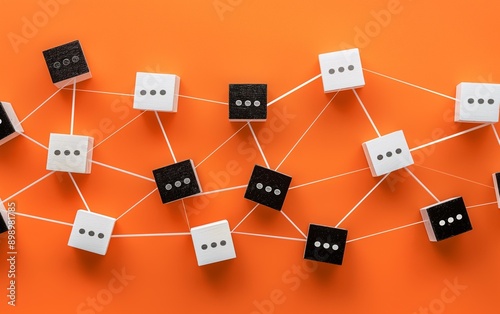 A minimalist arrangement of white and black wooden blocks with dots connected by lines on an orange background.