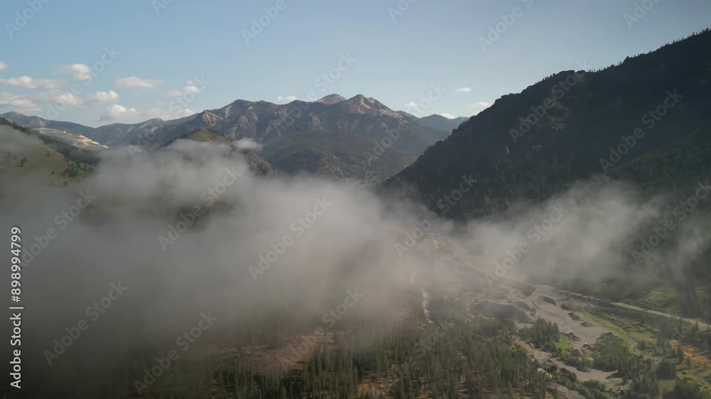 Aerial flying with low clouds above Yankee Fork basin in Sawtooth Mountains in summer in early morning Aerial flying with low clouds above Yankee Fork basin in Sawtooth Mountains in summer in early morning