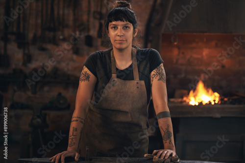 Portrait, serious and woman at metal factory for foundry industry, manufacturing and hardware steel production. Female blacksmith, fire furnace and iron welding labor, trade and maintenance worksop photo