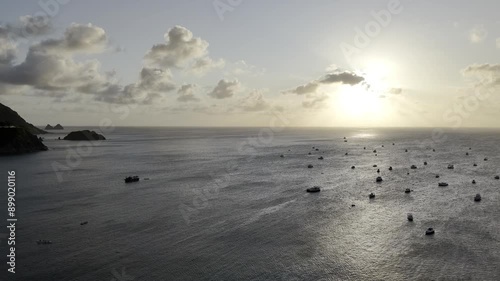 Drone floats to the left over boat porto gazing into a sunset with sporadic clouds