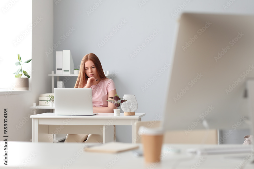 Female programmer working with laptop at table in office