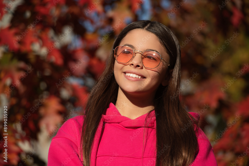 Fall season. Girl dreams in autumn fall. Autumn mood of adolescent model. Autumn leaves in park outdoor. Girl portrait. Autumn teen girl wearing in sunglasses and looks stylish. PInk color Fall season. Girl dreams in autumn fall. Autumn mood of adolescent model. Autumn leaves in park outdoor. Girl portrait. Autumn teen girl wearing in sunglasses and looks stylish. PInk color