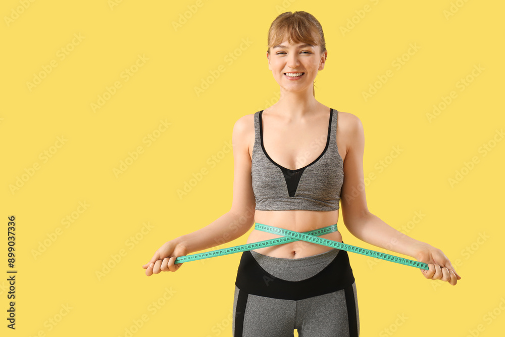 Beautiful young sporty woman measuring her waist on yellow background. Weight loss concept Beautiful young sporty woman measuring her waist on yellow background. Weight loss concept