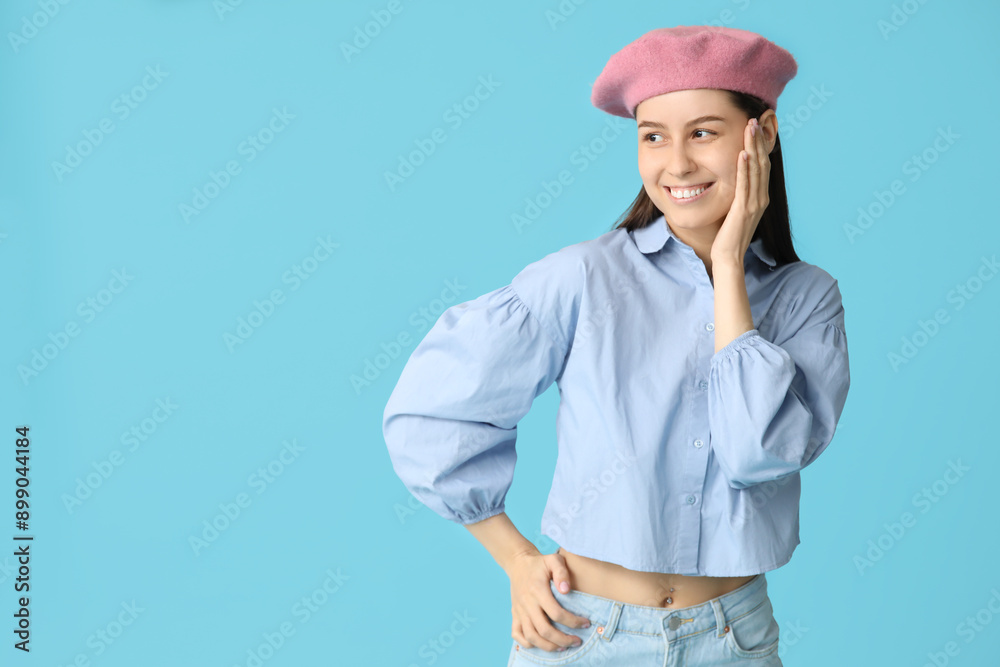Beautiful young woman in stylish pink beret hat on blue background Beautiful young woman in stylish pink beret hat on blue background