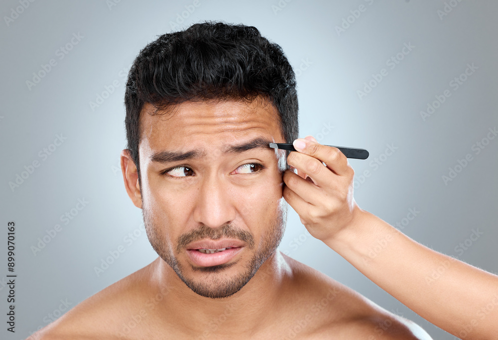 Eyebrow, pain and man with tweezers in studio for hair removal, hygiene and facial treatment. Skincare, beauty and person anxious with tool for epilation, self care and grooming on white background Eyebrow, pain and man with tweezers in studio for hair removal, hygiene and facial treatment. Skincare, beauty and person anxious with tool for epilation, self care and grooming on white background