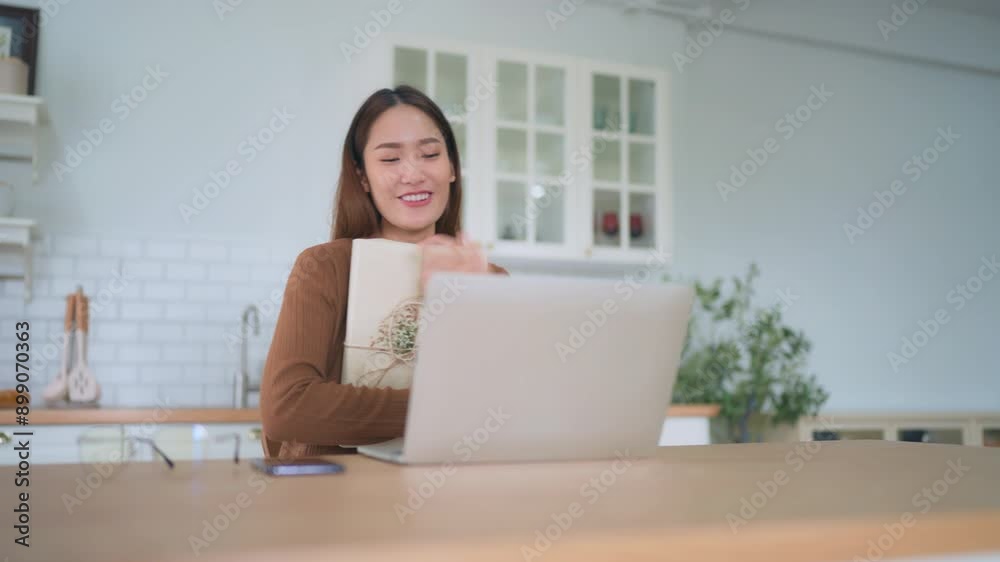 Young asian woman using computer laptop at home. Female showing gift box while on video conversation with friend. Happy birthday, Happy new year, Thanksgiving day Young asian woman using computer laptop at home. Female showing gift box while on video conversation with friend. Happy birthday, Happy new year, Thanksgiving day