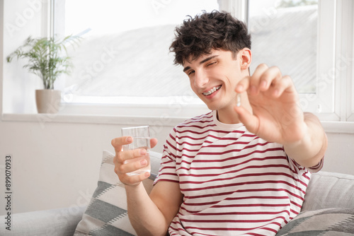 Young man taking fish oil a...
