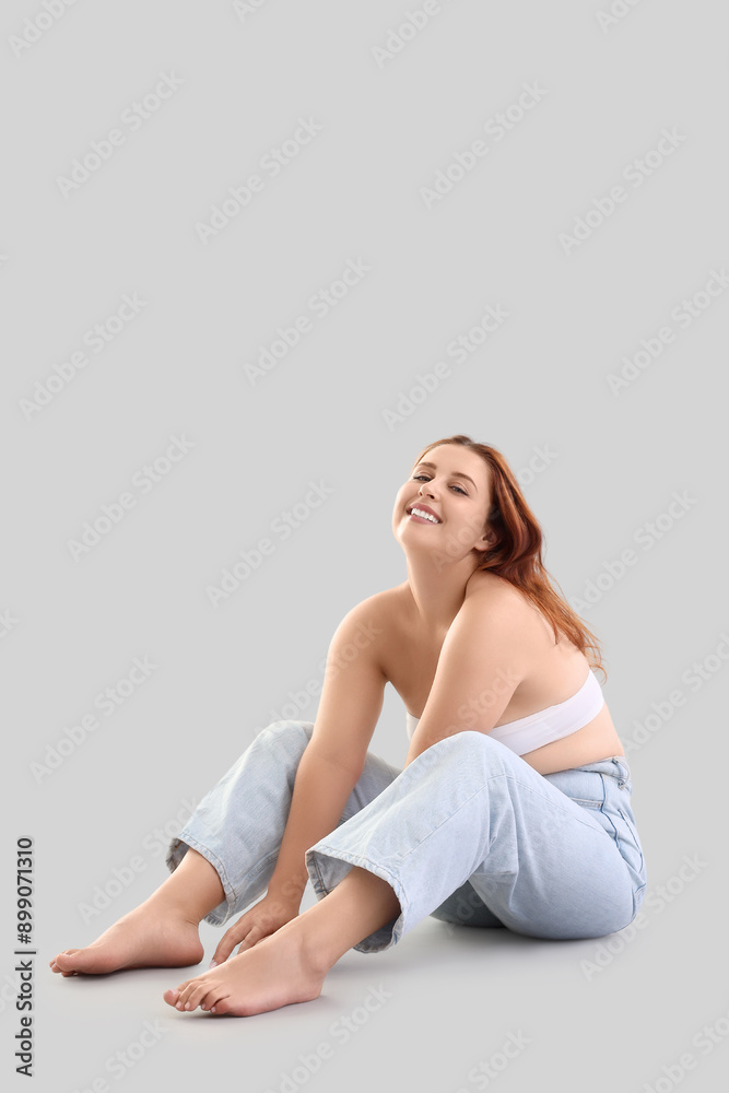 Beautiful plus size woman sitting on light background Beautiful plus size woman sitting on light background