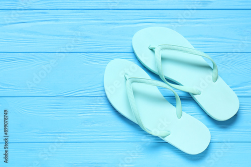 Beach flip-flops on blue wooden background © Pixel-Shot