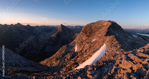 Sunset wide angle panorama of Norwegian mountain ridge hike. Midnight sun trekking in arctic Norway. Dawn, dusk and blue hour during fjelltur in Helgeland. Breitind, Smaltind and Tortenviktind hike.  photo