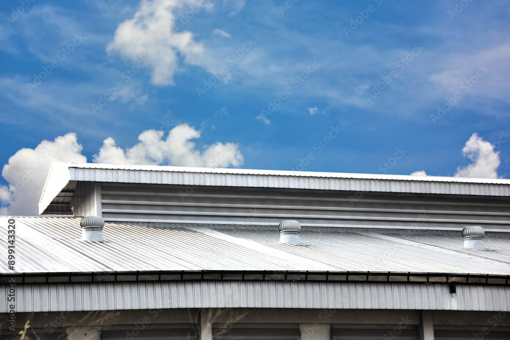 metal sheet roof tile of warehouse with ventilation fan on roof on blue sky white cloud metal sheet roof tile of warehouse with ventilation fan on roof on blue sky white cloud
