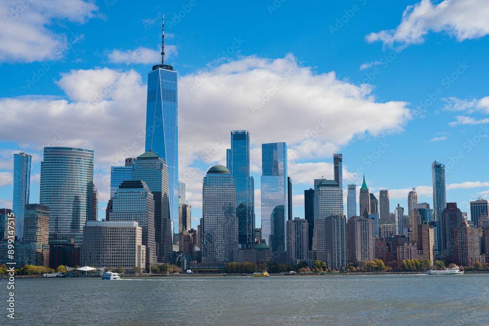 Obraz premium The city skyline of New York City in USA, United States. Blue sky day with iconic buildings. New York City NYC Manhattan Downtown Skyline, viewed from Jersey City, USA.